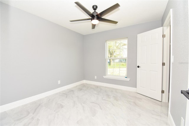 spare room featuring baseboards and a ceiling fan