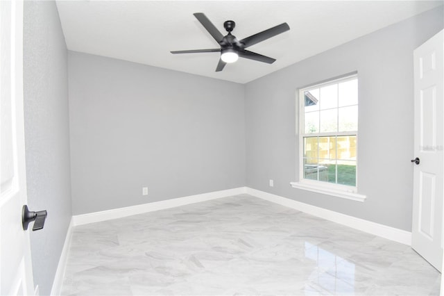unfurnished bedroom featuring marble finish floor, baseboards, and a ceiling fan