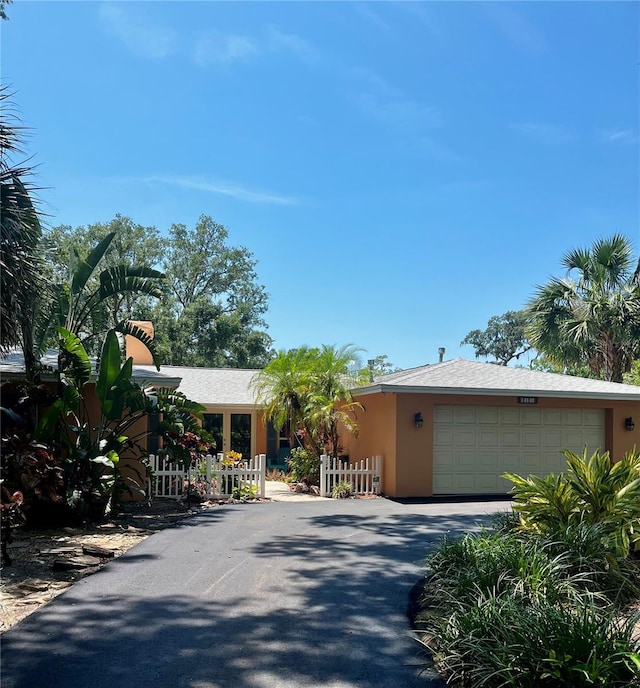 2121 Suzanne Dr, Mount Dora, FL 32757 - view of front of home featuring an attached garage, stucco siding, and asphalt driveway