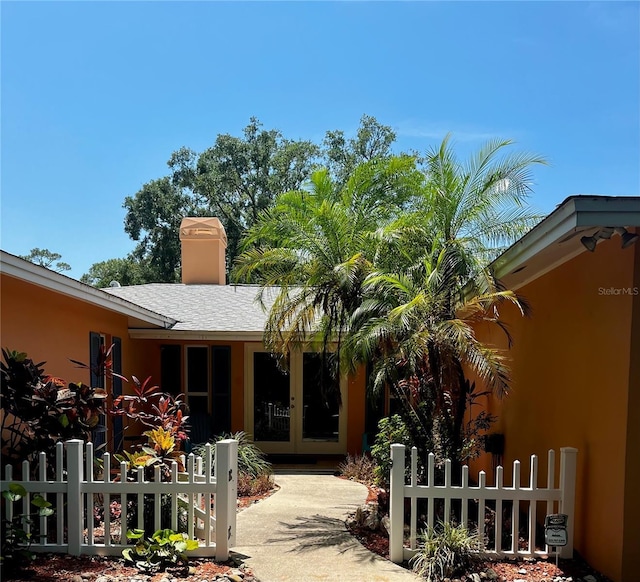 2121 Suzanne Dr, Mount Dora, FL 32757 - rear view of house with french doors, a chimney, and stucco siding