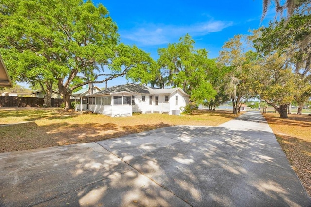 16724 Highland Ave, Montverde, FL 34756 - ranch-style house with a sunroom, driveway, and central AC