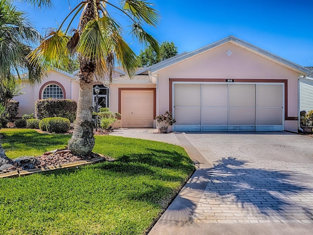 910 Eagles Lndg, Leesburg, FL 34748 - view of front of home featuring stucco siding, a front lawn, decorative driveway, and a garage