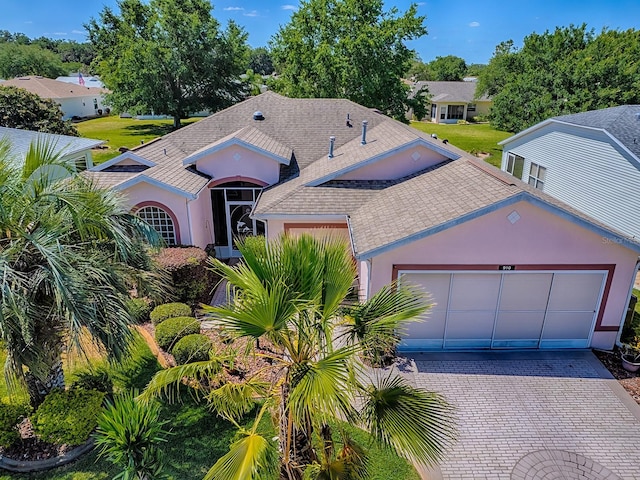 910 Eagles Lndg, Leesburg, FL 34748 - view of front of house with roof with shingles, stucco siding, decorative driveway, and an attached garage