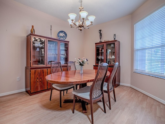 910 Eagles Lndg, Leesburg, FL 34748 - dining room featuring a chandelier, light wood-style floors, and baseboards