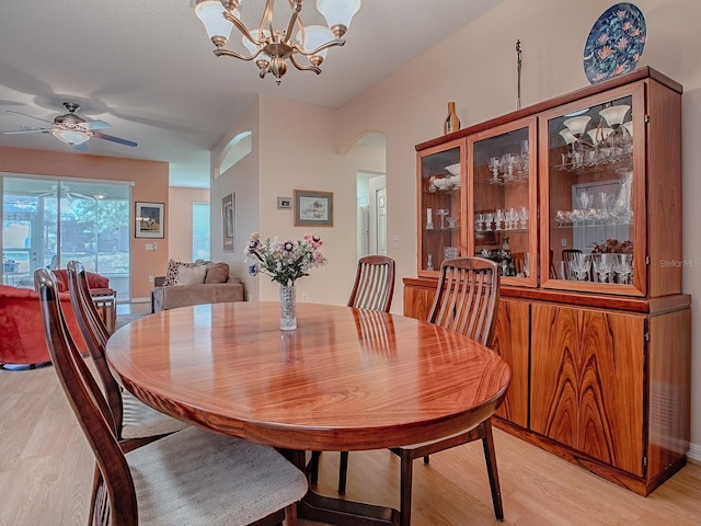 910 Eagles Lndg, Leesburg, FL 34748 - dining room featuring light wood-type flooring, arched walkways, a chandelier, and a ceiling fan