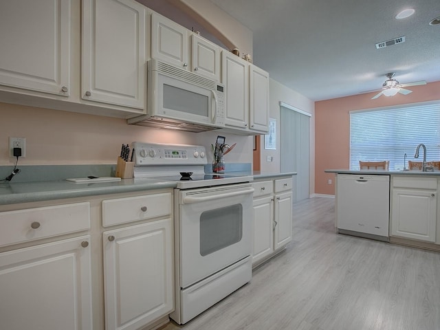 910 Eagles Lndg, Leesburg, FL 34748 - kitchen with white appliances, ceiling fan, light wood-style floors, and white cabinets