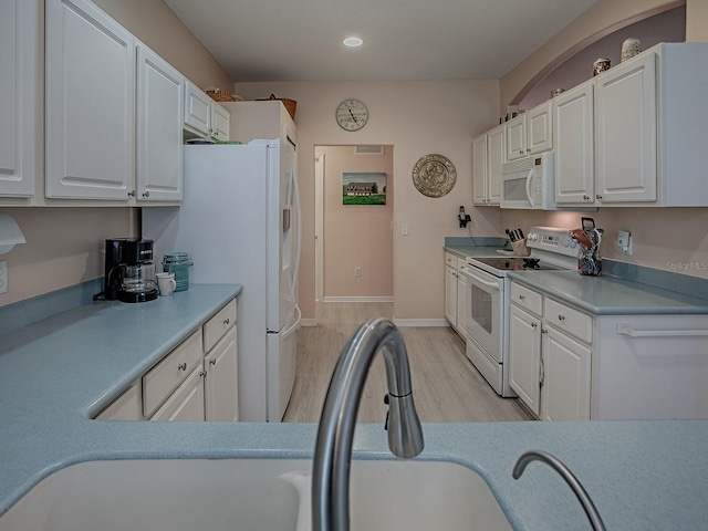 910 Eagles Lndg, Leesburg, FL 34748 - kitchen featuring white appliances, white cabinetry, recessed lighting, and light countertops