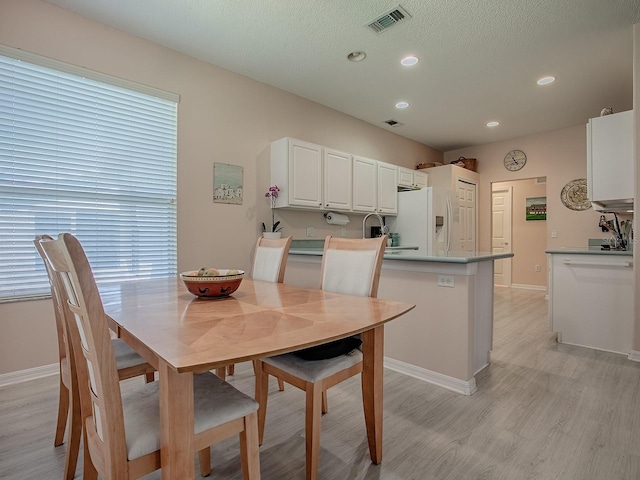 910 Eagles Lndg, Leesburg, FL 34748 - dining area featuring light wood-style flooring, recessed lighting, baseboards, and a textured ceiling