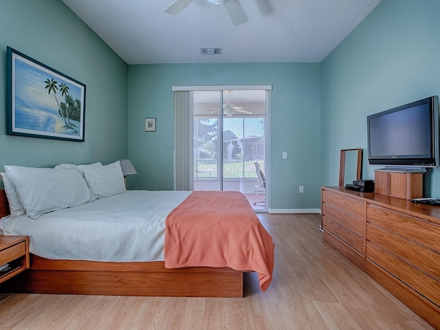 910 Eagles Lndg, Leesburg, FL 34748 - bedroom with access to outside, light wood finished floors, baseboards, a ceiling fan, and a textured ceiling