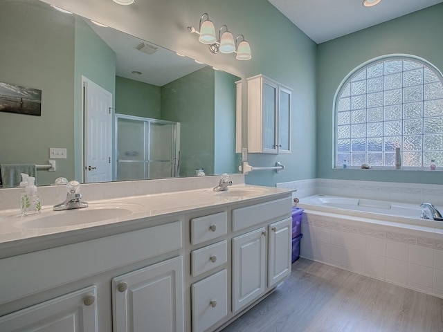 910 Eagles Lndg, Leesburg, FL 34748 - full bath featuring a shower stall, a garden tub, double vanity, and wood finished floors