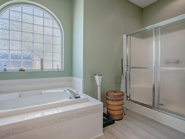 910 Eagles Lndg, Leesburg, FL 34748 - full bath with a shower stall, wood finished floors, healthy amount of natural light, and a garden tub