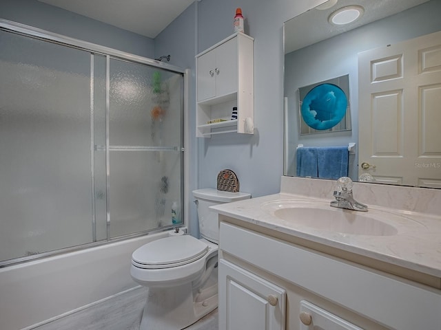 910 Eagles Lndg, Leesburg, FL 34748 - bathroom featuring vanity, bath / shower combo with glass door, toilet, and wood finished floors