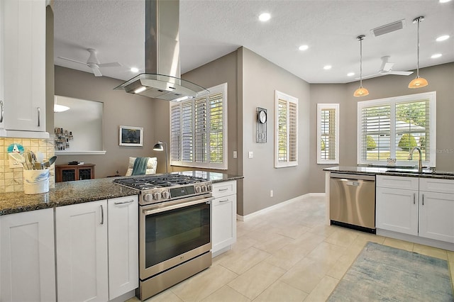 kitchen with island exhaust hood, backsplash, visible vents, stainless steel appliances, and a sink