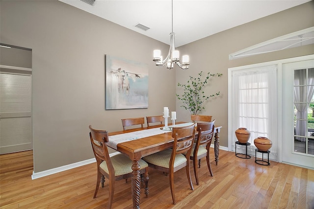 dining room featuring a chandelier, light wood-style floors, baseboards, and visible vents