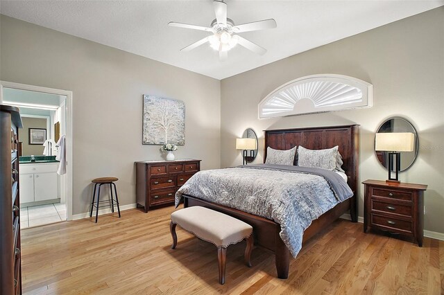 bedroom with light wood-style flooring, ceiling fan, baseboards, and connected bathroom