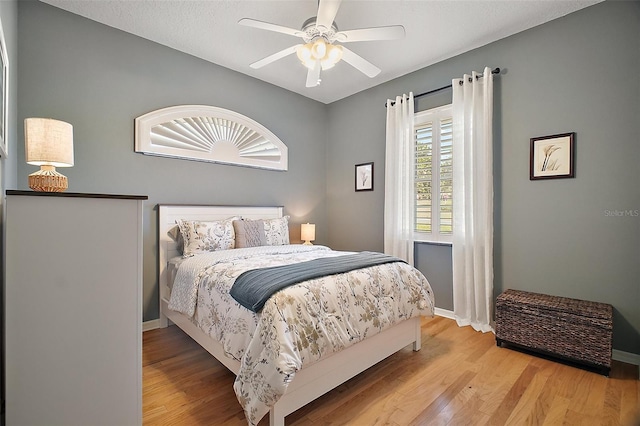 bedroom with baseboards, a ceiling fan, and wood finished floors