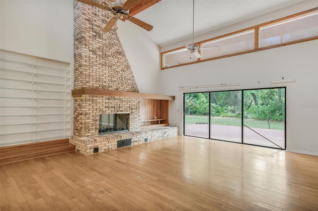 8640 E Henderson Trl, Inverness, FL 34450 - unfurnished living room featuring a ceiling fan, wood finished floors, high vaulted ceiling, and a fireplace