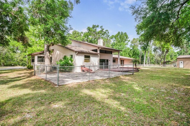 8640 E Henderson Trl, Inverness, FL 34450 - rear view of property featuring a chimney, stucco siding, a patio, and a lawn