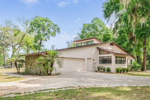 8640 E Henderson Trl, Inverness, FL 34450 - mid-century home featuring stucco siding, a garage, and decorative driveway
