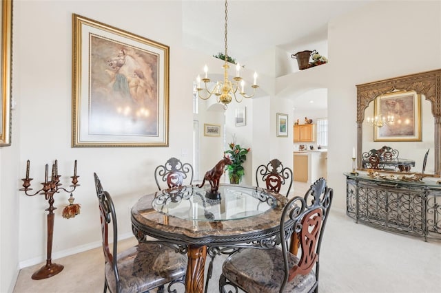 carpeted dining space featuring arched walkways and a notable chandelier