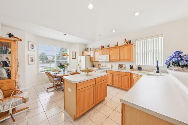 kitchen with light tile patterned floors, light countertops, white appliances, and a kitchen island