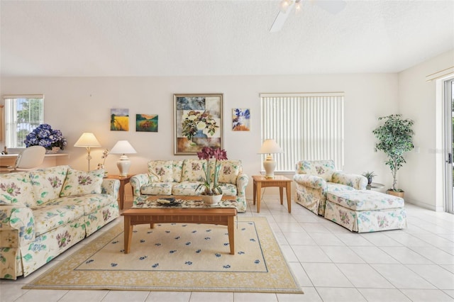 living area with tile patterned flooring, a textured ceiling, and a ceiling fan