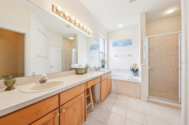 full bath featuring a bath, a sink, double vanity, tile patterned floors, and a stall shower