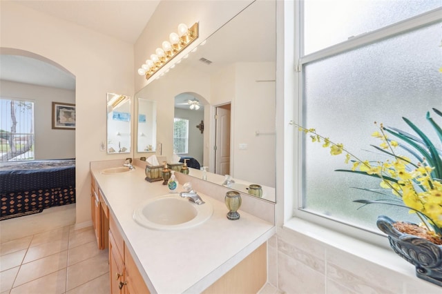 ensuite bathroom with double vanity, ensuite bath, a sink, and tile patterned flooring
