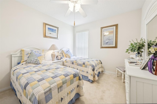 bedroom featuring light colored carpet, baseboards, and a ceiling fan