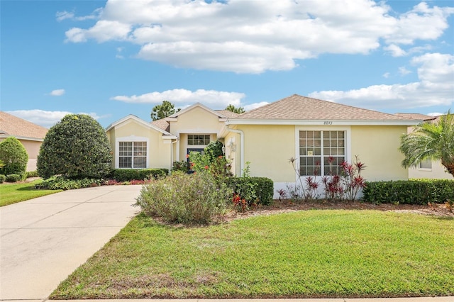 ranch-style home with stucco siding and a front lawn