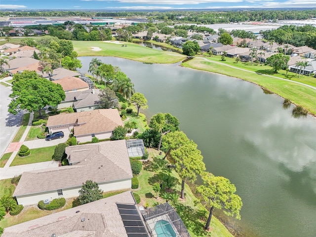 drone / aerial view featuring golf course view, a residential view, and a water view