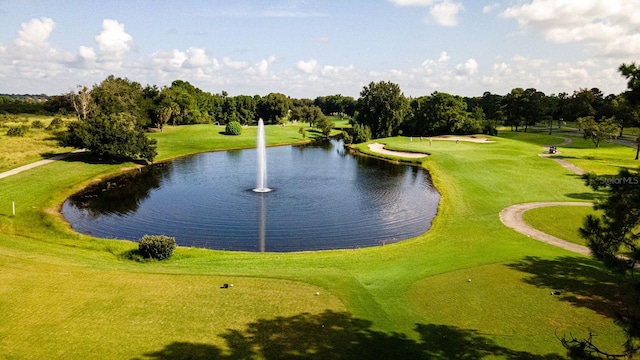 exterior space with a lawn, view of golf course, and a water view