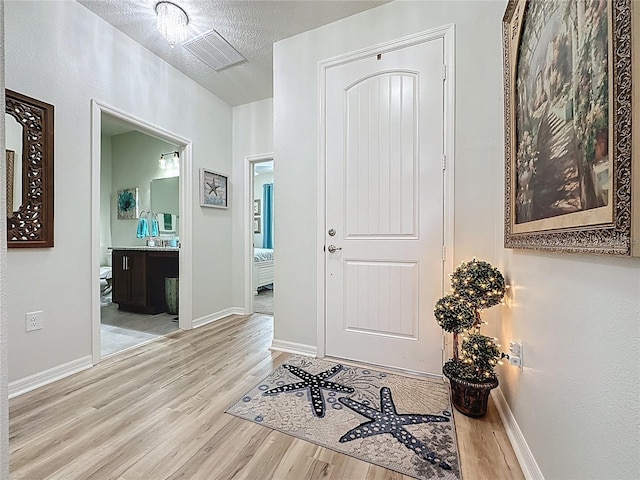 entrance foyer featuring wood finished floors, visible vents, and baseboards