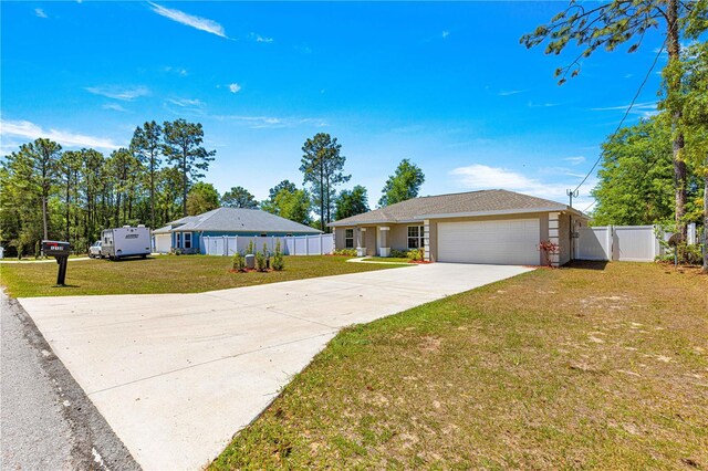 ranch-style home featuring concrete driveway, fence, an attached garage, a gate, and a front lawn