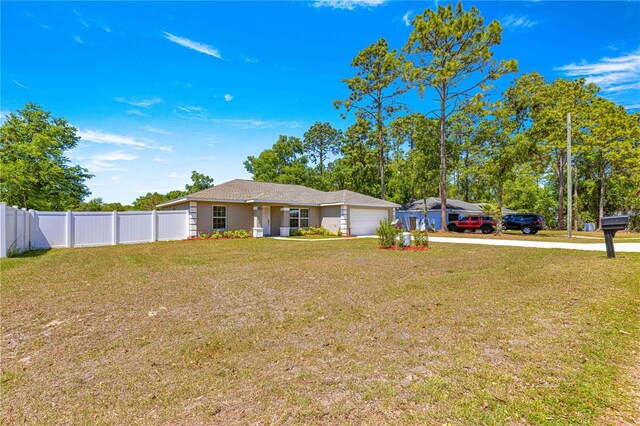 view of yard featuring driveway, a garage, and fence