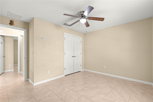 unfurnished bedroom featuring attic access, baseboards, ceiling fan, visible vents, and a closet