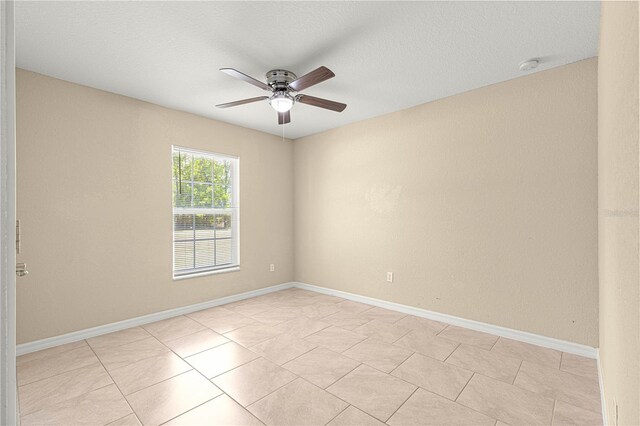 unfurnished room with baseboards, a textured ceiling, and a ceiling fan