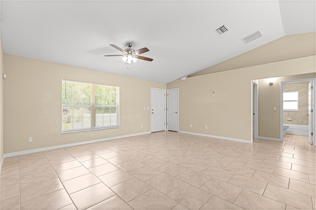 unfurnished room featuring lofted ceiling, baseboards, light tile patterned flooring, ceiling fan, and visible vents
