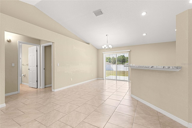 empty room with light tile patterned flooring, lofted ceiling, baseboards, visible vents, and an inviting chandelier