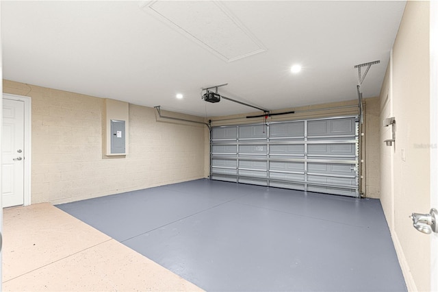 garage featuring concrete block wall, electric panel, and a garage door opener