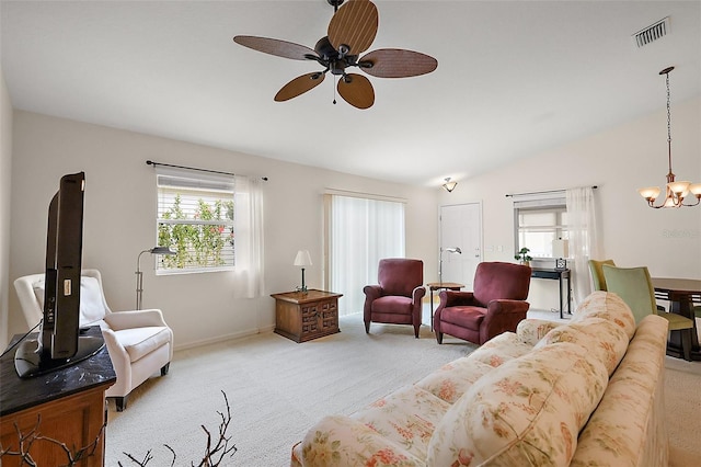 living room with ceiling fan with notable chandelier, vaulted ceiling, visible vents, and carpet floors