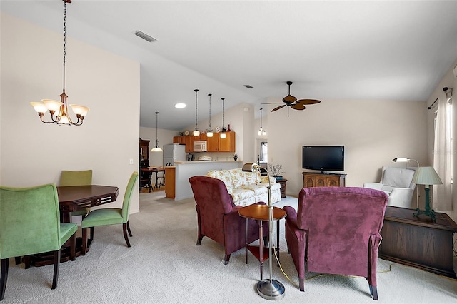 living room with visible vents, a wealth of natural light, vaulted ceiling, ceiling fan with notable chandelier, and light colored carpet
