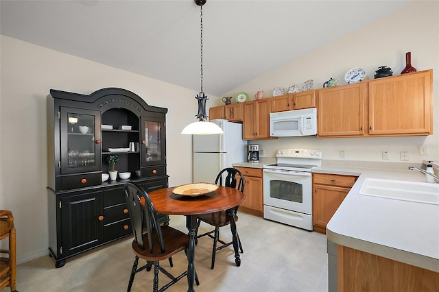 kitchen with white appliances, light countertops, lofted ceiling, pendant lighting, and a sink