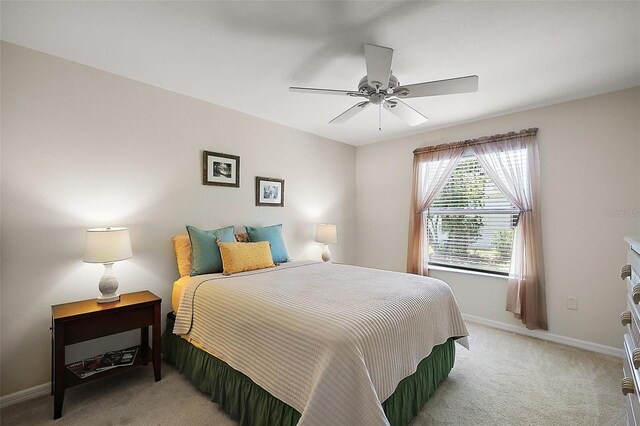 2290 Due W Dr, The Villages, FL 32162 - bedroom featuring light colored carpet, baseboards, and a ceiling fan