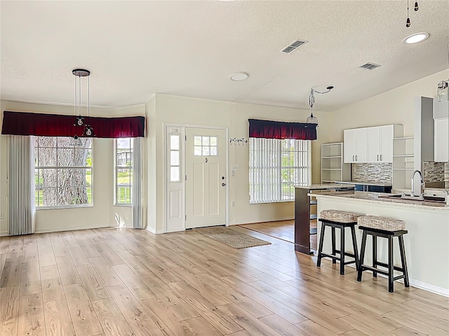 kitchen with visible vents, light wood-style flooring, and a sink