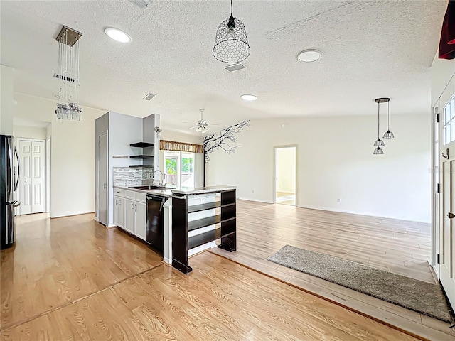 kitchen with light wood finished floors, a sink, visible vents, and dishwasher