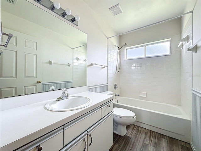 full bathroom with visible vents, toilet, wood finished floors, vanity, and  shower combination