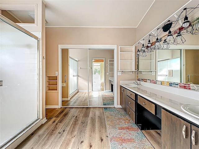 bathroom with double vanity, a sink, baseboards, and wood finished floors