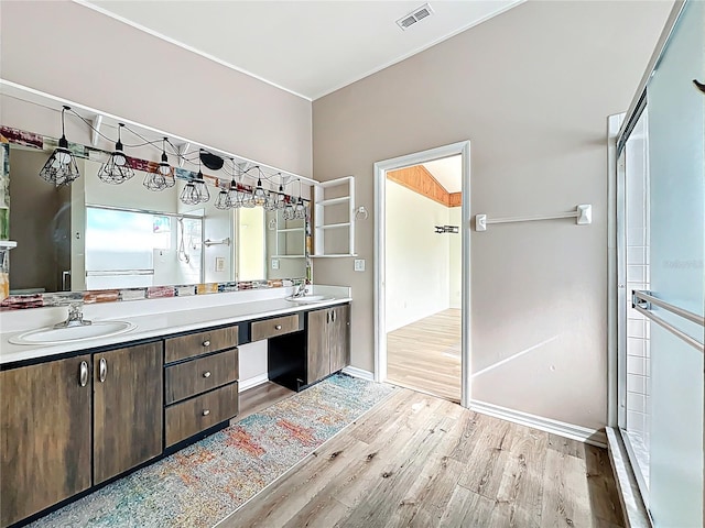 full bath with double vanity, visible vents, wood finished floors, and a sink