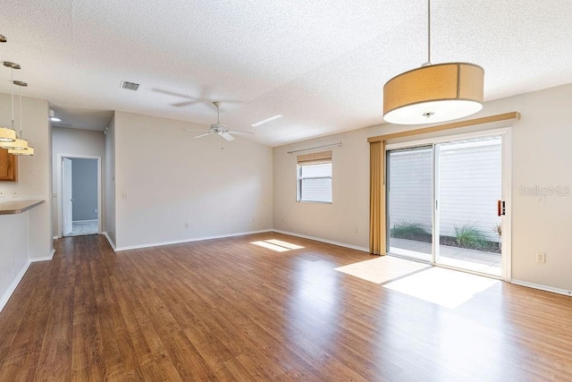 1667 Osprey Ave, The Villages, FL 32162 - unfurnished living room with baseboards, a textured ceiling, visible vents, a ceiling fan, and wood finished floors